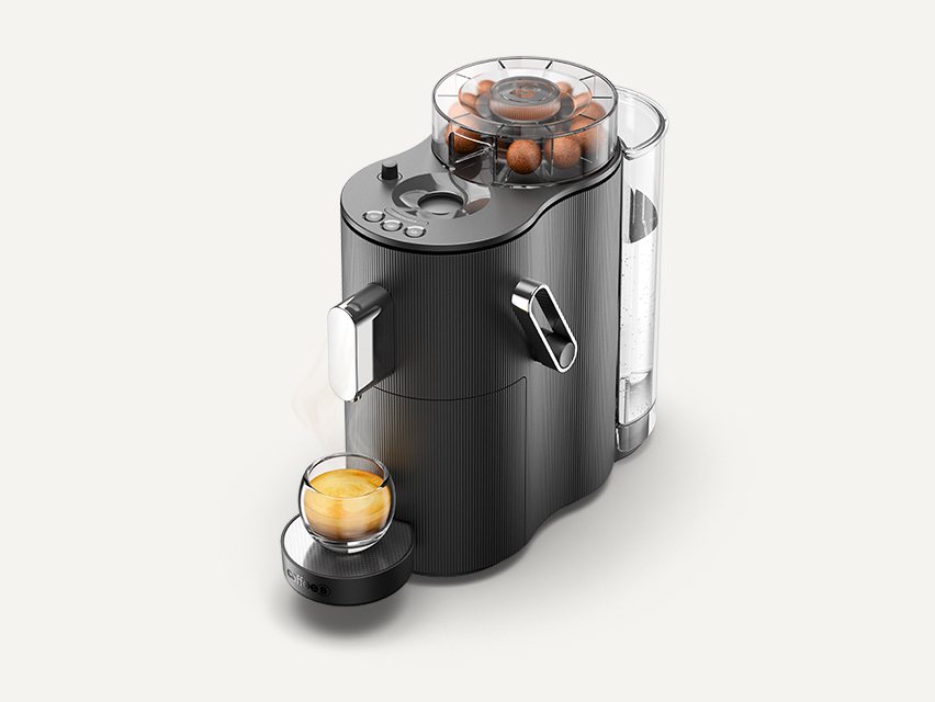Eine schwarze CoffeeB Kaffeemaschine mit gefülltem Ball Dispenser und einem gefüllten Kaffee-Glas.