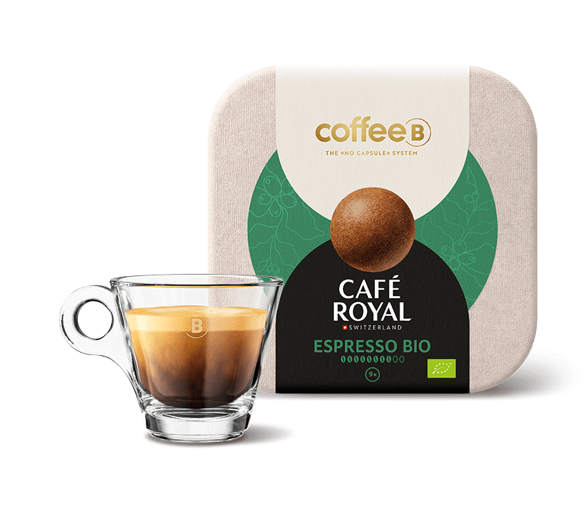 Neun Coffee Balls Espresso Bio von CoffeeB mit einer gefüllten CoffeeB Espresso-Tasse.
